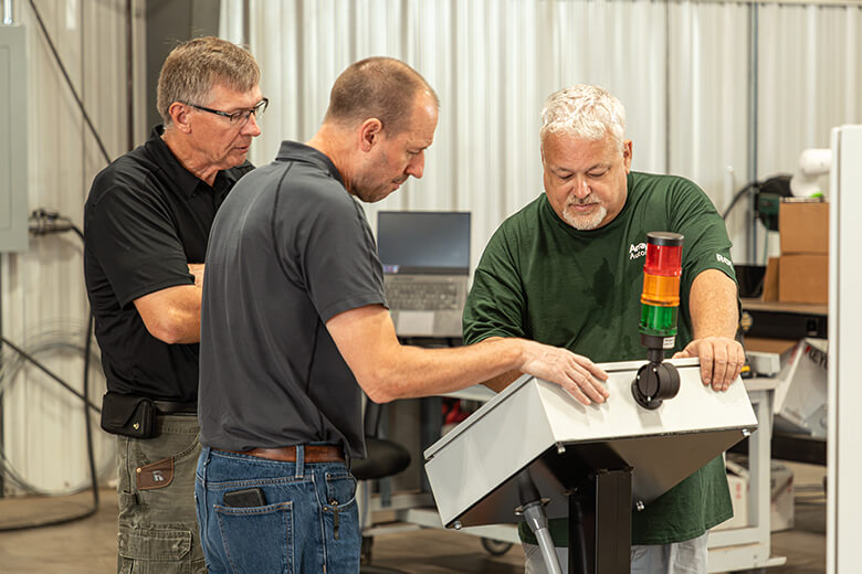 three men around a control console