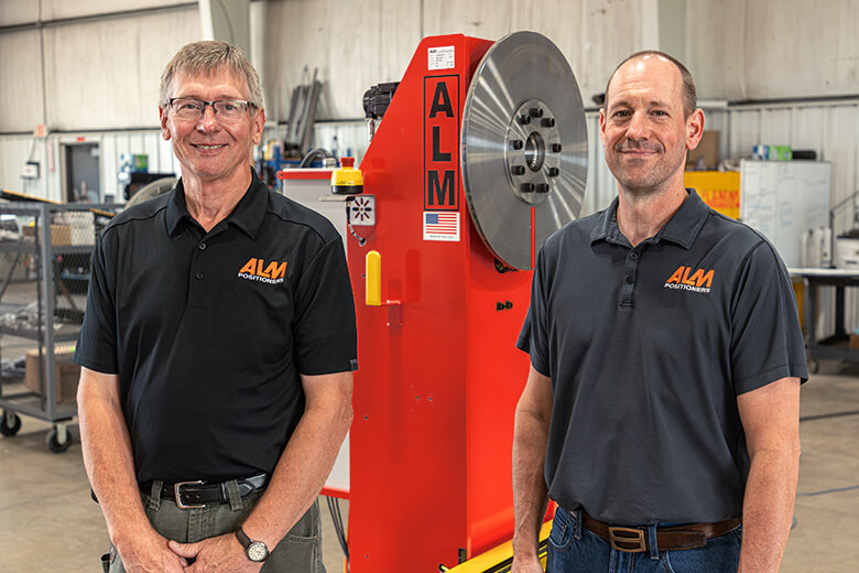 Photo of ALM employees next to a positioner