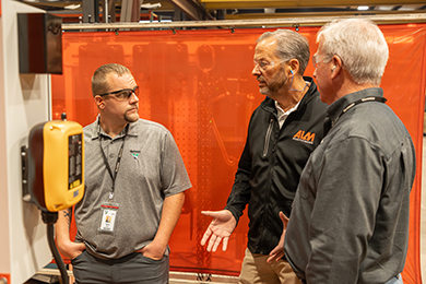 Three men chatting next to control